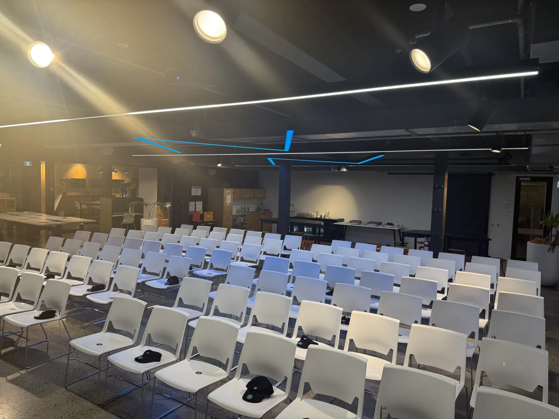 Rows of seats with Cursor swag caps before the meetup started