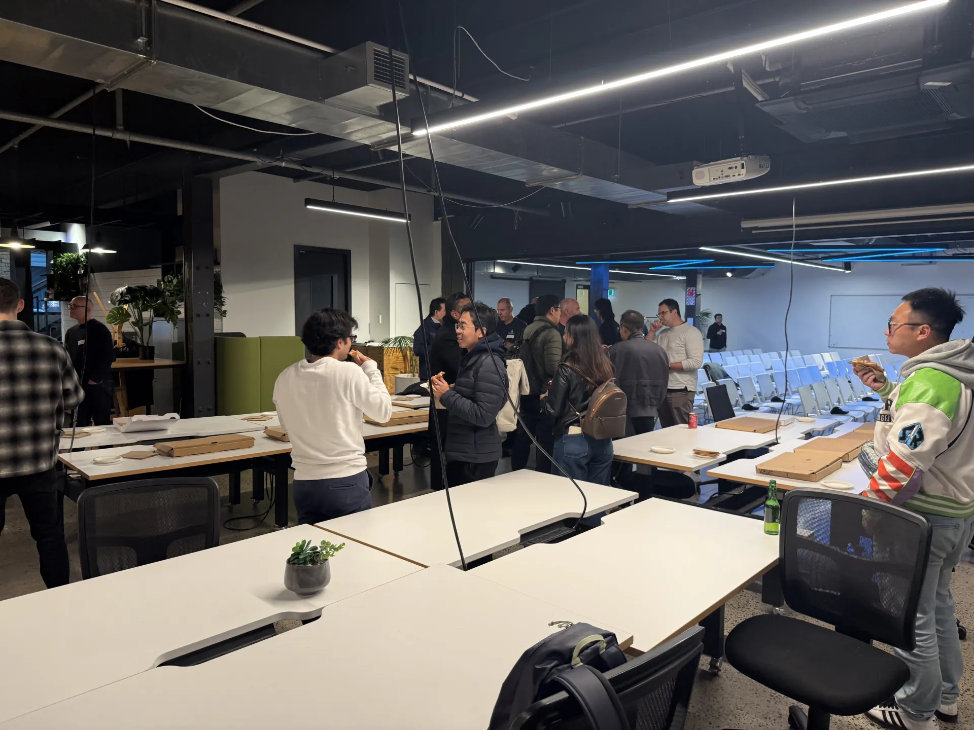 Attendees networking over pizza in the GridAKL workspace