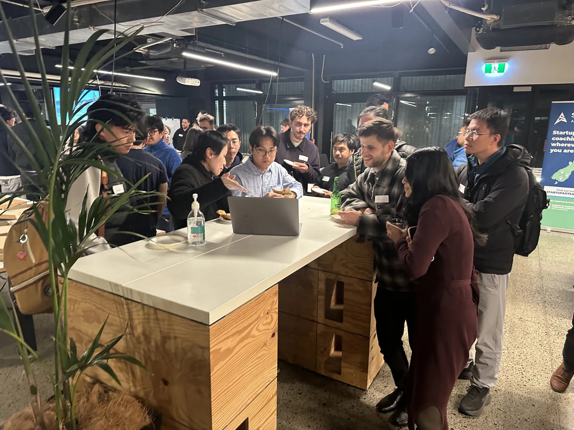 Attendees gathered around a laptop during a live demo